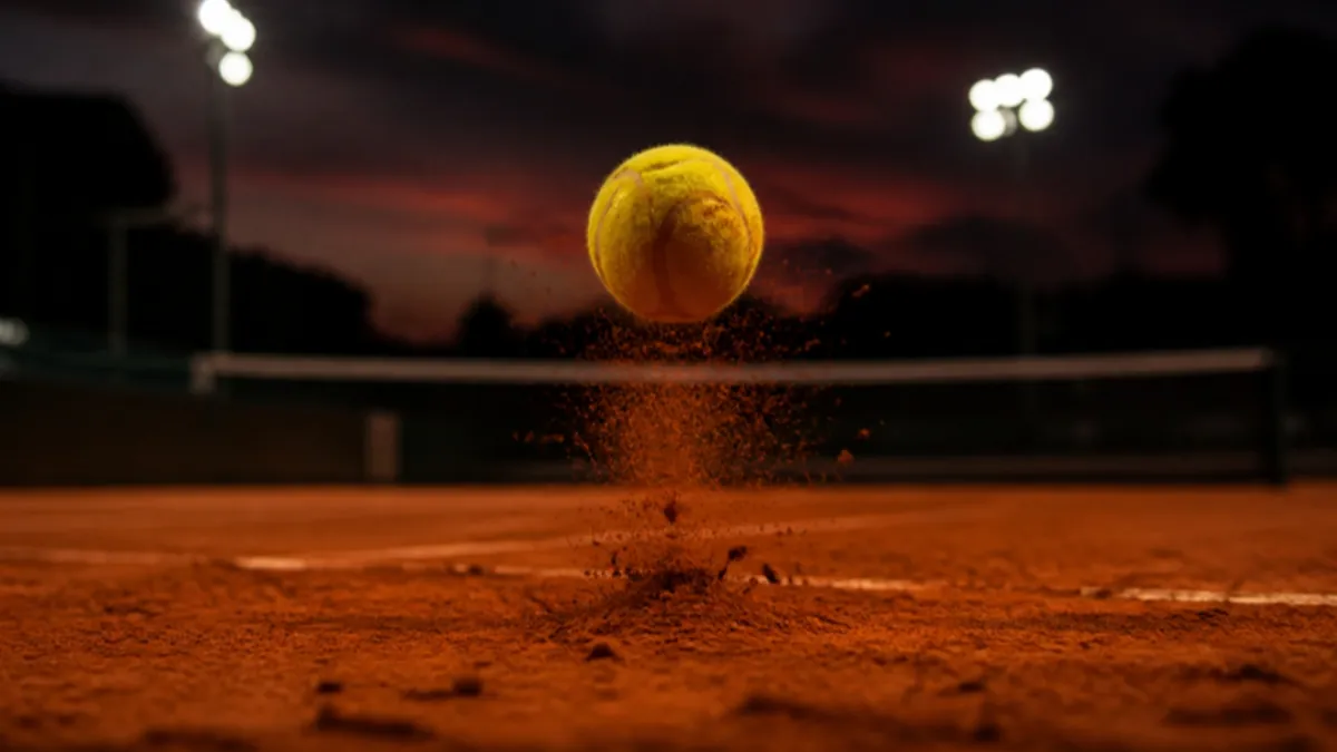 Sandplatz: Tennisball springt hoch ab, Sand staubt auf